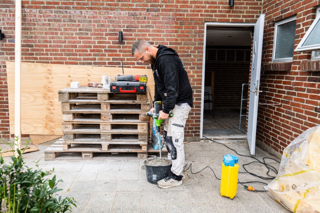 Murer blander mørtel på byggepladsen
